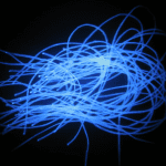 Blue fiber-optic cables glow brightly against a black background, creating a tangled, swirling pattern.